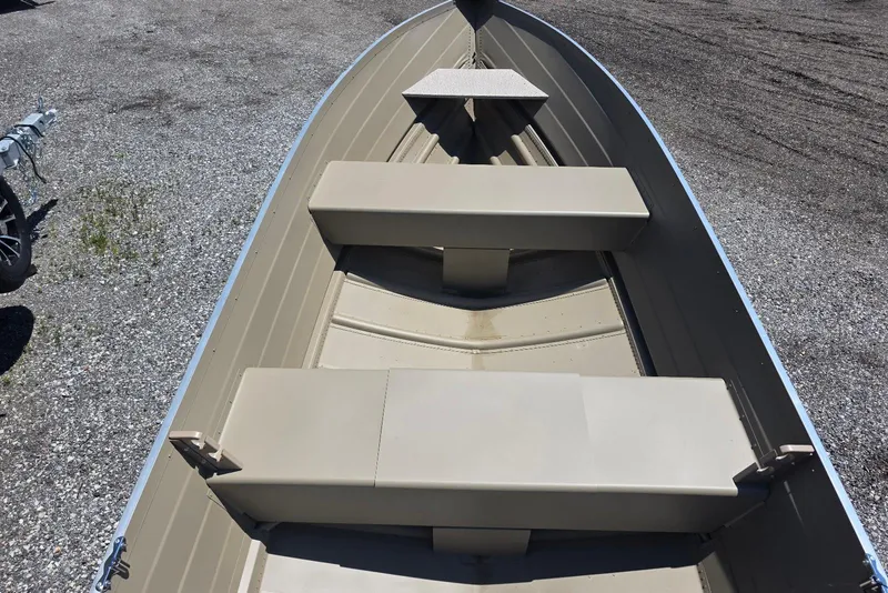Slide: The Image of 2026 Smoker Craft Voyager 16 boat interior with beige seating and aluminum hull. - 5
