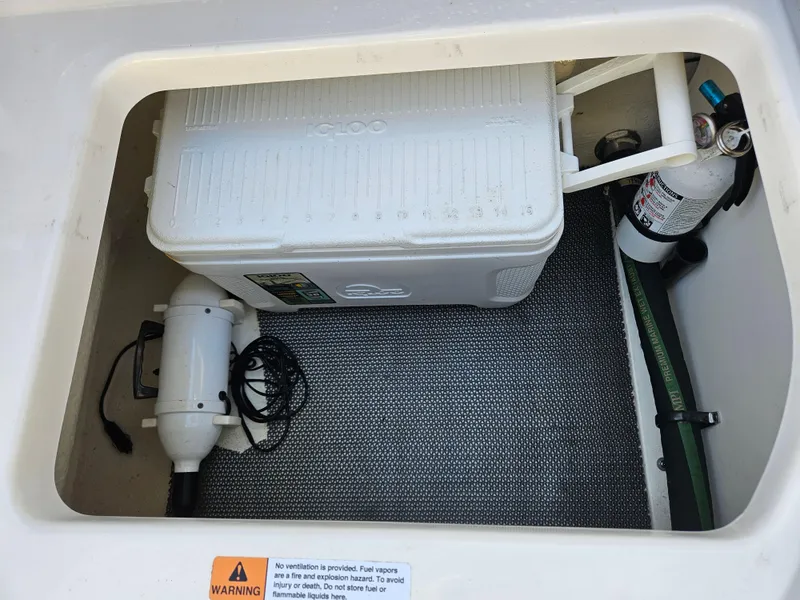Slide: The Image of Storage compartment in 2020 Chaparral 230 Suncoast with cooler and fire extinguisher. - 23
