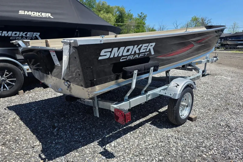 Slide: The Image of 2026 Smoker Craft Voyager 16 boat on trailer, displayed outdoors. - 2