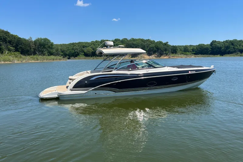 Slide: The Image of 2014 Formula 350 Crossover Bowrider I/O on a serene lake with lush green surroundings. - 2