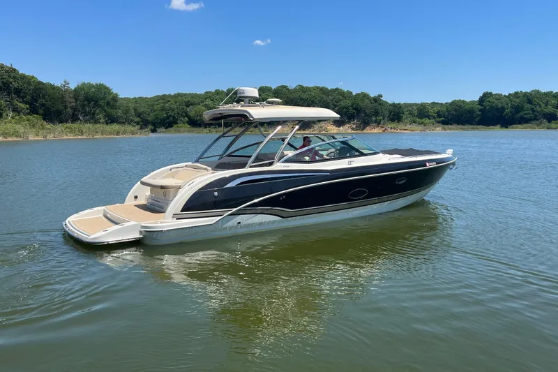 Slide: The Image of 2014 Formula 350 Crossover Bowrider I/O on a serene lake with lush green surroundings. - 3