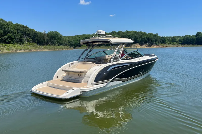 Slide: The Image of 2014 Formula 350 Crossover Bowrider I/O on a serene lake with lush green surroundings. - 6