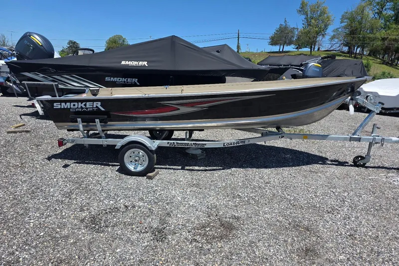 The Image of 2026 Smoker Craft Voyager 16 boat on trailer, parked outdoors on gravel. - 0