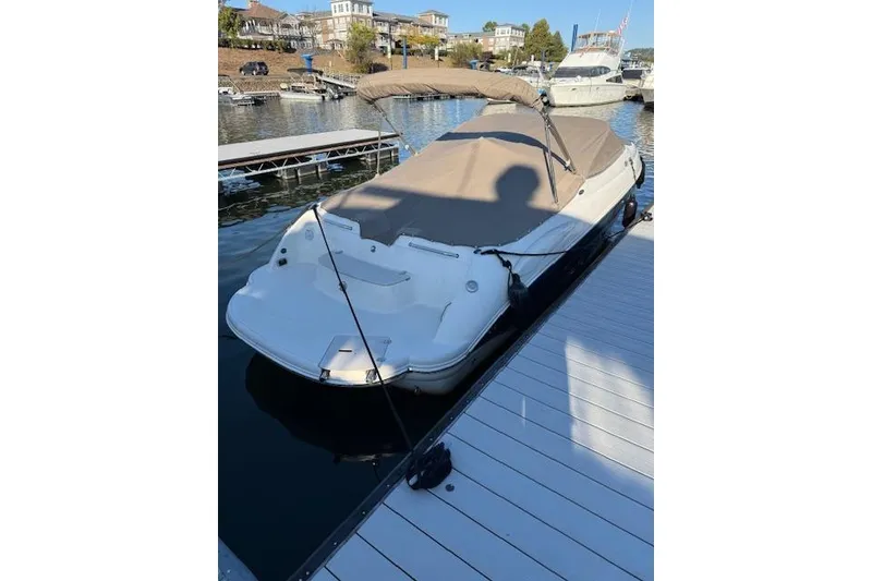 Slide: The Image of 2014 Stingray 250 LR boat docked at marina with cover. - 2