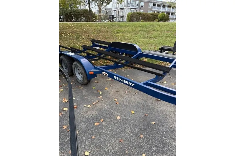 Slide: The Image of Blue Stingray 250 LR boat trailer, 2014 model, parked on asphalt with autumn leaves. - 7