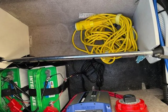 Slide: The Image of 2014 Stingray 250 LR boat battery compartment with cables and charger. - 8