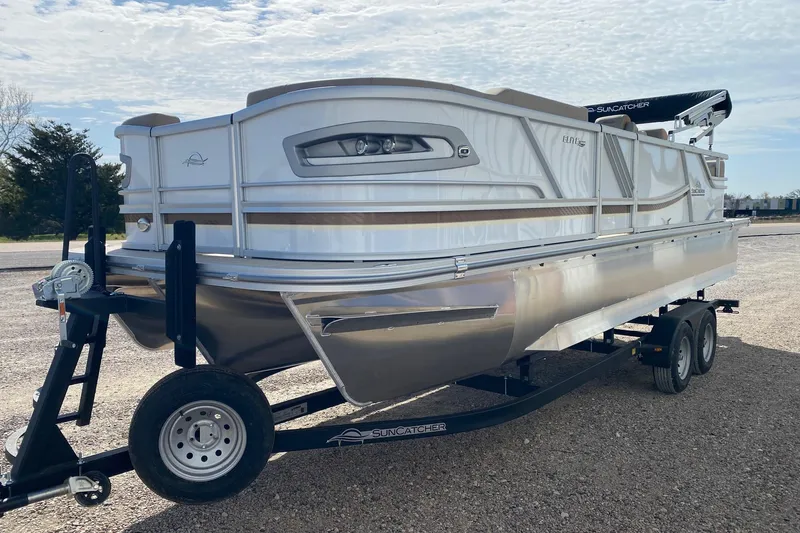 Slide: The Image of 2026 SunCatcher Elite 324 SS pontoon boat on trailer, parked outdoors. - 3