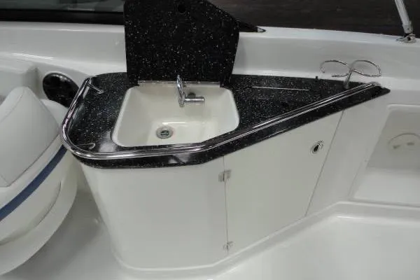 Slide: The Image of 2015 Monterey 264FS boat sink with black countertop and storage cabinet. - 12