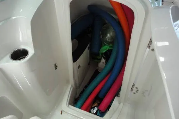 Slide: The Image of Storage compartment of 2015 Monterey 264FS boat filled with colorful pool noodles. - 14