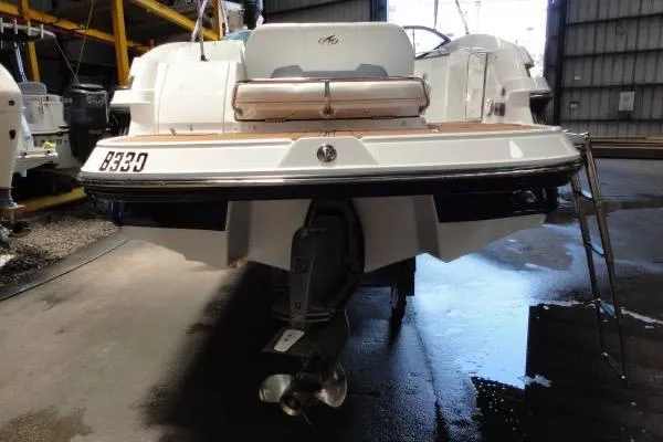 Slide: The Image of 2015 Monterey 264FS boat in storage, rear view with visible propeller and ladder. - 2