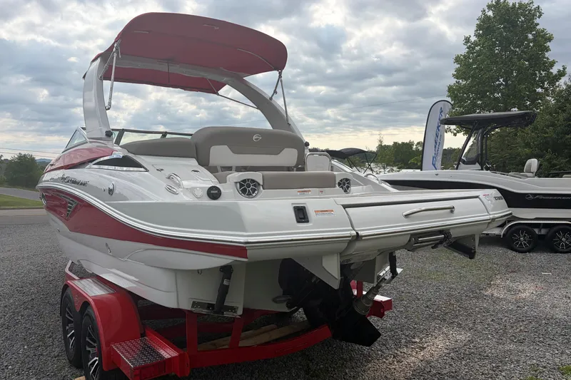 Slide: The Image of 2026 Crownline 278 SS boat with red accents on a trailer, parked outdoors. - 3
