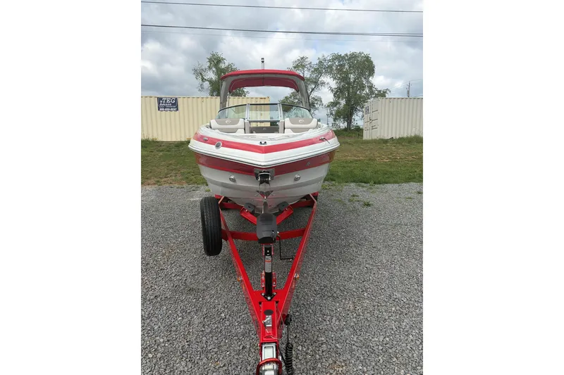 Slide: The Image of 2026 Crownline 278 SS boat on red trailer, parked on gravel. - 4