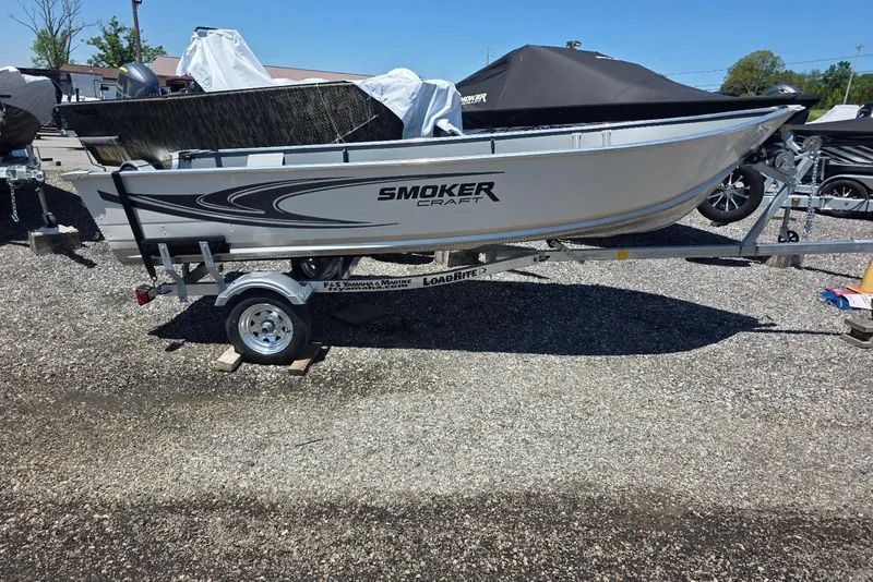 The Image of 2026 Smoker Craft Alaskan 15 TS DLX boat on trailer, parked outdoors. - 0