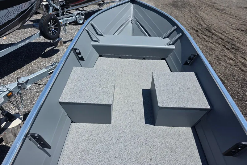 Slide: The Image of 2026 Smoker Craft Alaskan 15 TS DLX boat interior with gray seating and flooring. - 4