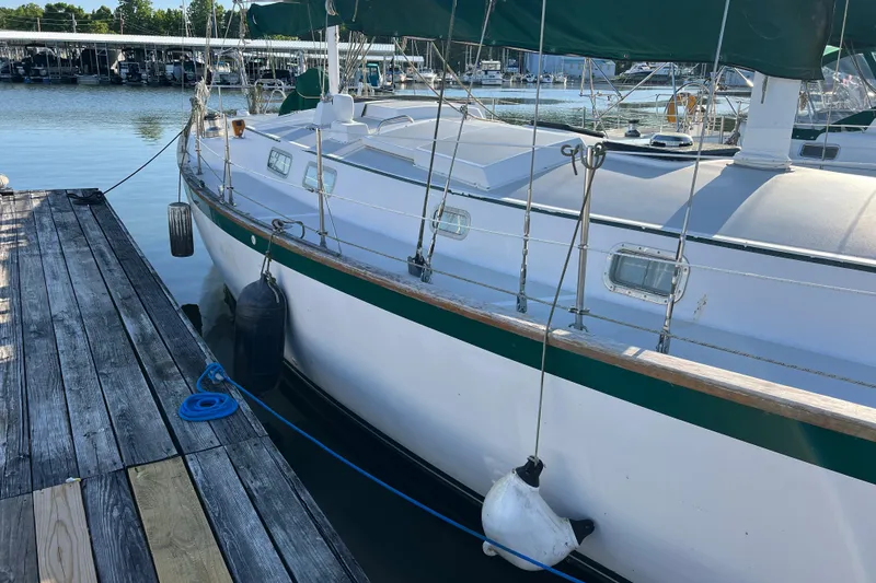 Slide: The Image of 1979 Pearson 424 sailboat docked at marina with green trim and fenders. - 10