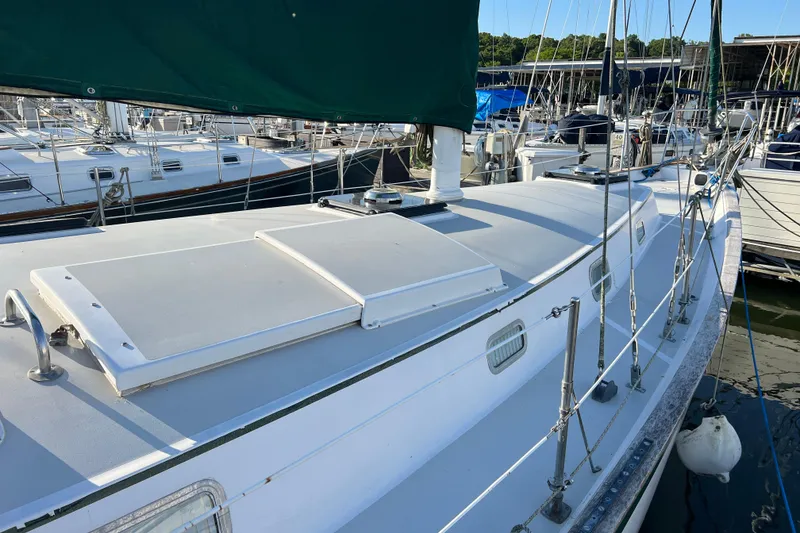 Slide: The Image of 1979 Pearson 424 sailboat docked, featuring a clean deck and green sail cover. - 11