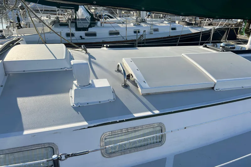 Slide: The Image of 1979 Pearson 424 sailboat deck with hatches and rigging in marina setting. - 12