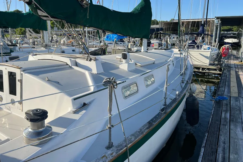Slide: The Image of 1979 Pearson 424 sailboat docked at marina, featuring white deck and green sail cover. - 22