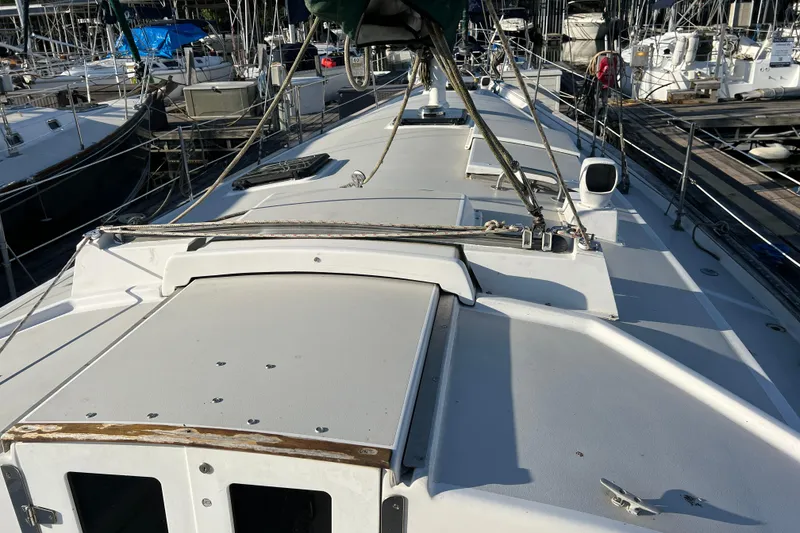 Slide: The Image of 1979 Pearson 424 sailboat deck view at marina, showcasing rigging and hatches. - 30
