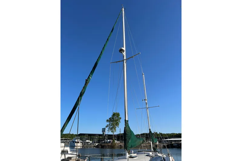 Slide: The Image of 1979 Pearson 424 sailboat with tall mast against clear blue sky at marina. - 4