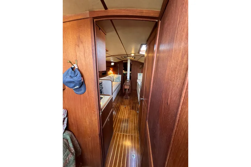Slide: The Image of Interior view of a 1979 Pearson 424 sailboat with wooden paneling and cozy furnishings. - 42