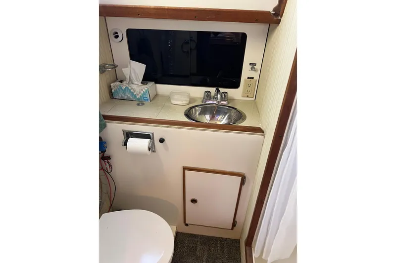 Slide: The Image of 1979 Pearson 424 boat bathroom with sink, mirror, and toilet paper holder. - 55