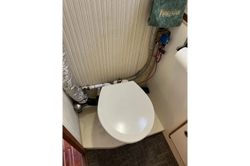 Slide: The Image of 1979 Pearson 424 boat bathroom with toilet and plumbing details. - 56