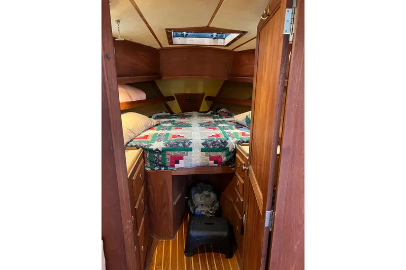 Slide: The Image of Cozy cabin interior of 1979 Pearson 424 sailboat with quilted bedding and wooden cabinetry. - 61