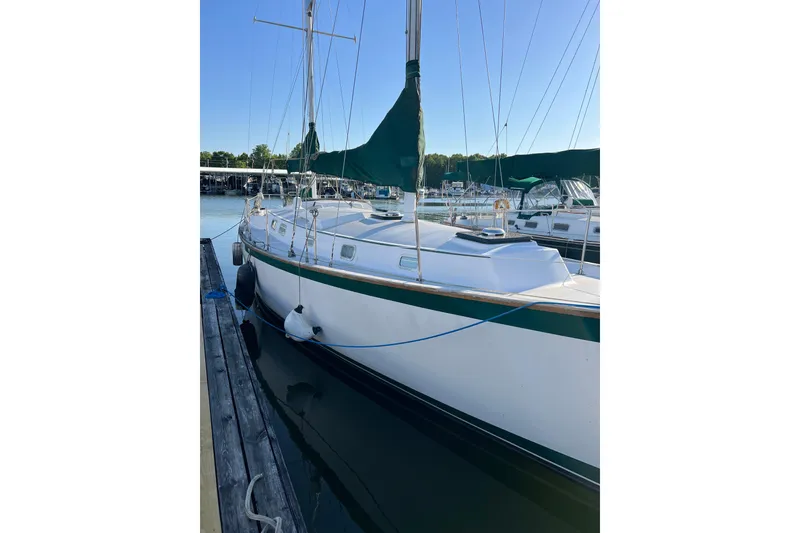 Slide: The Image of 1979 Pearson 424 sailboat docked at marina, featuring green sail cover. - 9