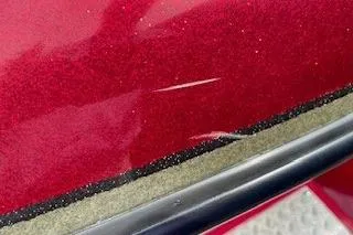 Slide: The Image of Close-up of a red 2002 Nitro NX 882 SC boat with visible scratches. - 23