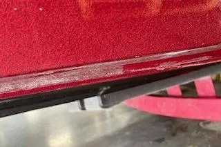 Slide: The Image of Close-up of a red 2002 Nitro NX 882 SC boat hull with visible wear. - 27