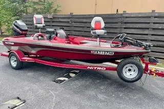 Slide: The Image of 2002 Nitro NX 882 SC fishing boat on trailer, red and white design, parked outdoors. - 3