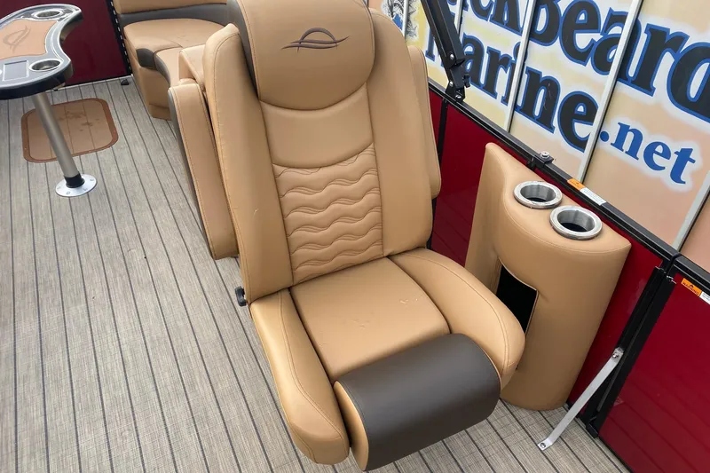 Slide: The Image of Luxurious seating on 2026 SunCatcher Fusion 324RC boat, featuring tan leather and cup holders. - 8