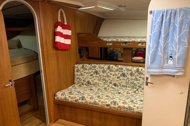 Slide: The Image of 1996 Luhrs 38 Open cabin interior with wood paneling and patterned seating. - 9