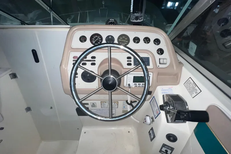 Slide: The Image of 1995 Rinker Fiesta Vee 265 boat dashboard with steering wheel and control panel. - 10