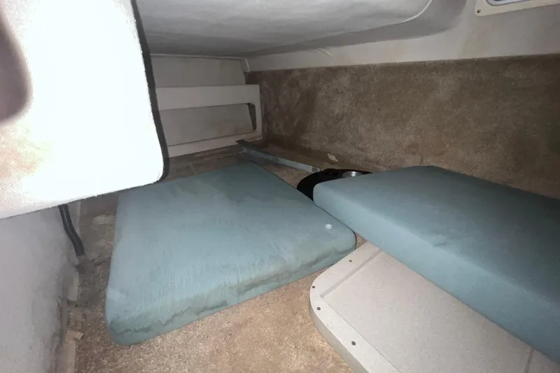 Slide: The Image of Interior cabin of 1995 Rinker Fiesta Vee 265 boat with cushions and storage space. - 18