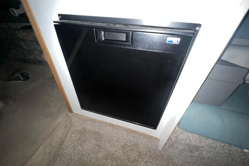 Slide: The Image of Built-in black refrigerator on 1995 Rinker Fiesta Vee 265 boat interior. - 19