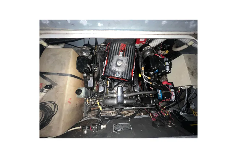 Slide: The Image of Engine compartment of a 1995 Rinker Fiesta Vee 265 boat, showcasing mechanical components. - 23