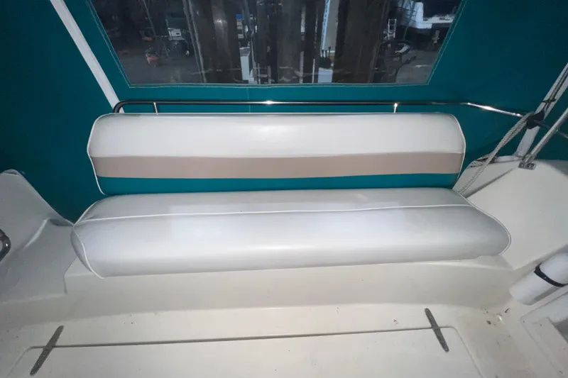 Slide: The Image of 1995 Rinker Fiesta Vee 265 boat interior with white cushioned seating. - 4
