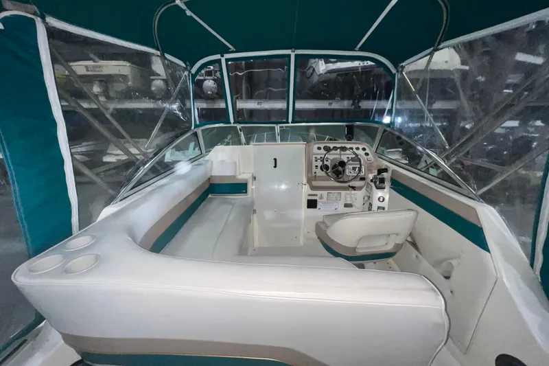 Slide: The Image of 1995 Rinker Fiesta Vee 265 boat interior with helm, seating, and canopy. - 5