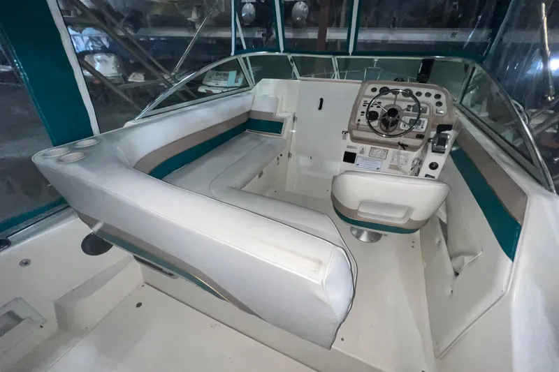 Slide: The Image of 1995 Rinker Fiesta Vee 265 boat interior with steering console and seating area. - 6