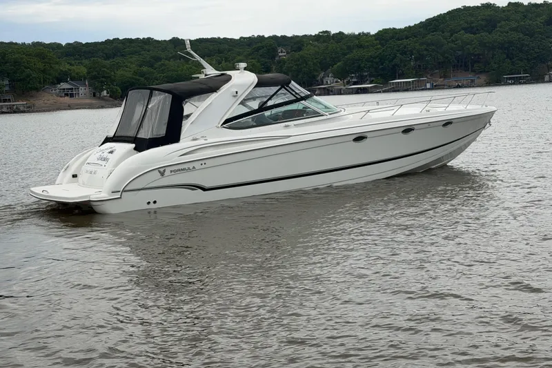 The Image of 2007 Formula 400 Super Sport boat on a calm lake with wooded shoreline. - 1