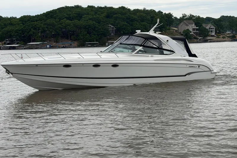 Slide: The Image of 2007 Formula 400 Super Sport boat on a calm lake with wooded shoreline. - 10
