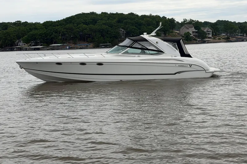 Slide: The Image of 2007 Formula 400 Super Sport boat cruising on a calm lake with wooded shoreline. - 11