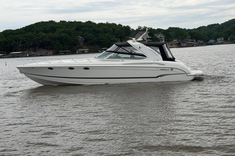 Slide: The Image of 2007 Formula 400 Super Sport boat cruising on a lake with wooded shoreline. - 12