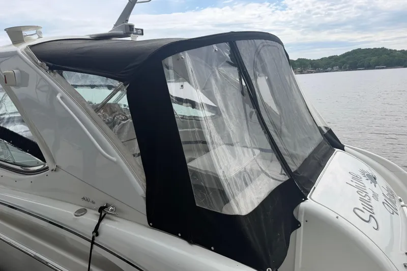 Slide: The Image of 2007 Formula 400 Super Sport boat with black canopy on a calm lake. - 16