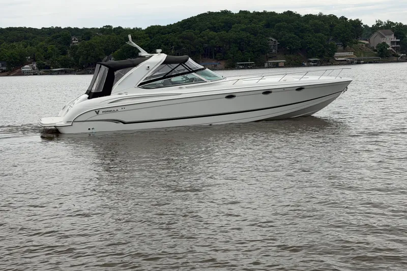 Slide: The Image of 2007 Formula 400 Super Sport boat cruising on a calm lake with lush green shoreline. - 3
