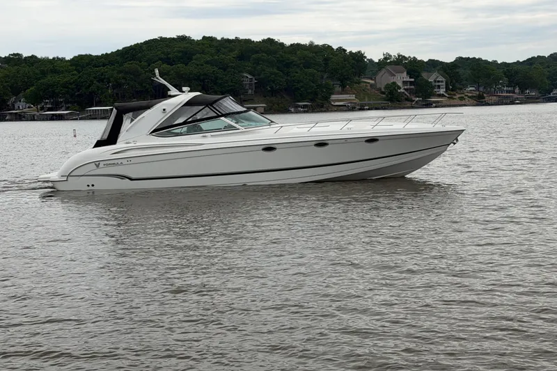 Slide: The Image of 2007 Formula 400 Super Sport boat cruising on a calm lake with wooded shoreline. - 4