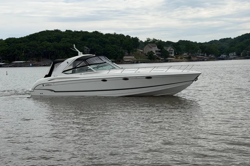 Slide: The Image of 2007 Formula 400 Super Sport boat cruising on a calm lake with wooded shoreline. - 5