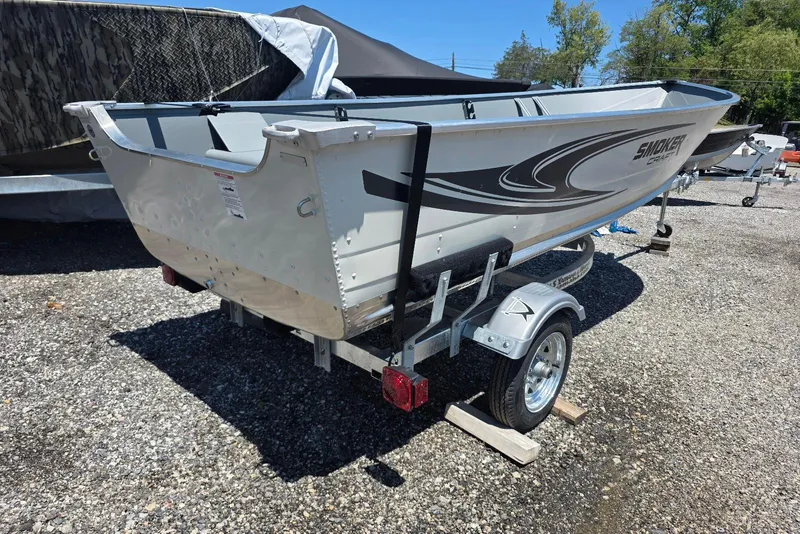 Slide: The Image of 2026 Smoker Craft Alaskan 15 TS DLX boat on trailer, parked outdoors. - 2